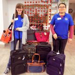 SVDP workers showing off luggage at St. Vincent de Paul Fond du Lac.