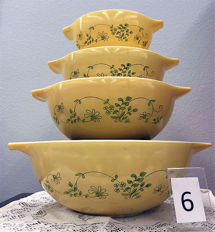 Yellow Pyrex bowls with green floral pattern.