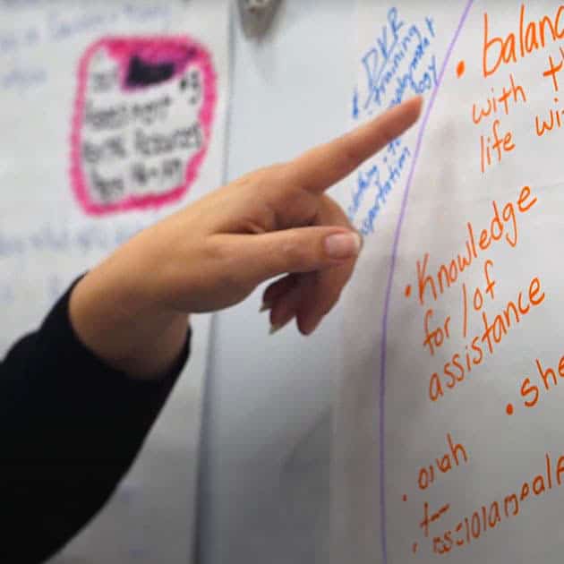 St. Vincent de Paul Fond du Lac County 3 A hand pointing at a whiteboard during a Getting Ahead Fond du Lac, ending poverty session.